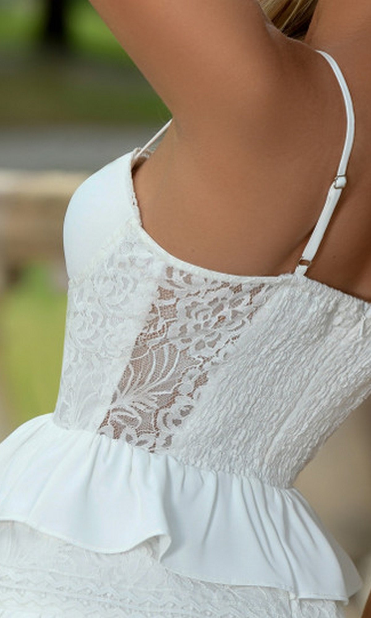 Close-up side view of a woman wearing the Kiara Short White Ruffled Graduation Party Dress, featuring thin straps, a ruffled peplum detail, and a delicate sheer corset bodice.